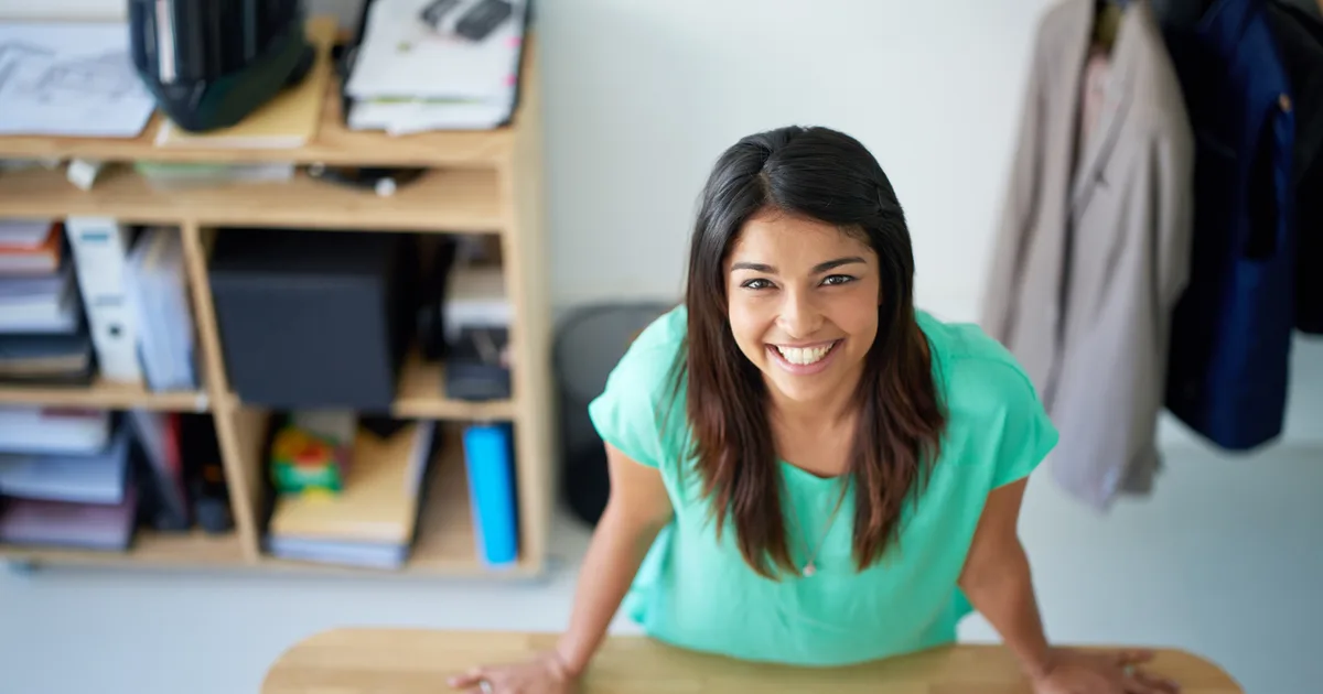 Une créatrice souriante à son bureau, à la maison