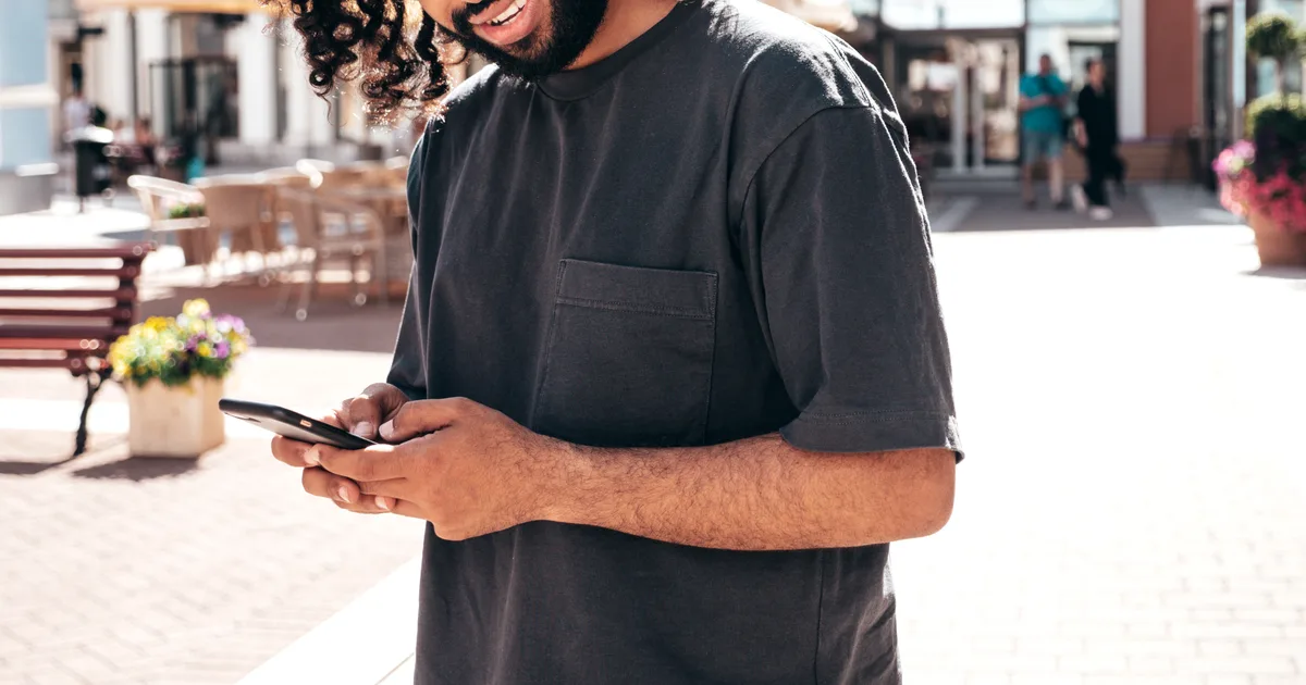 Un créateur consulte son téléphone dans la rue