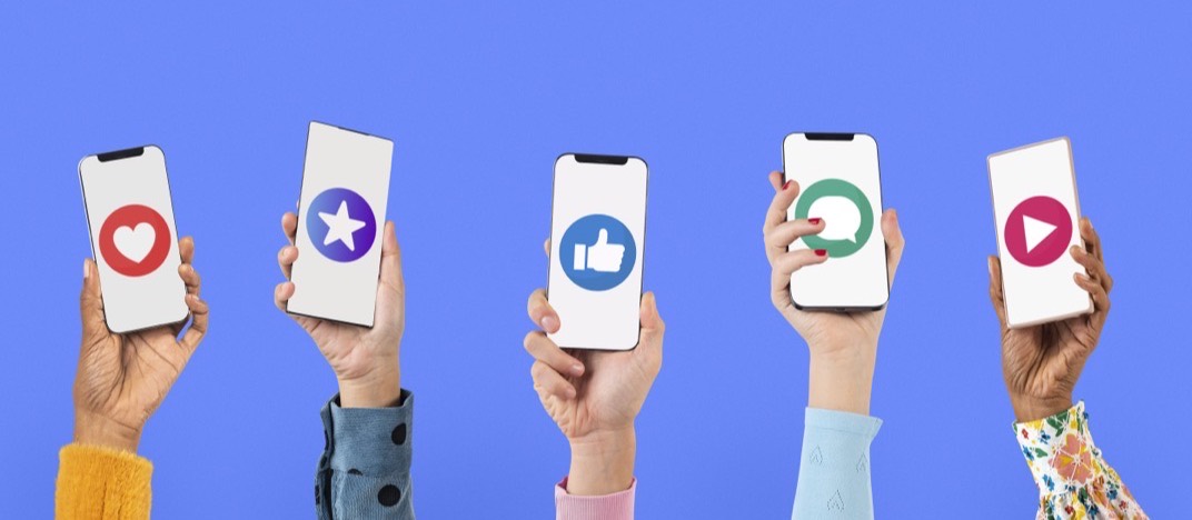 Des mains tendent des smartphones avec des icônes de réseaux sociaux