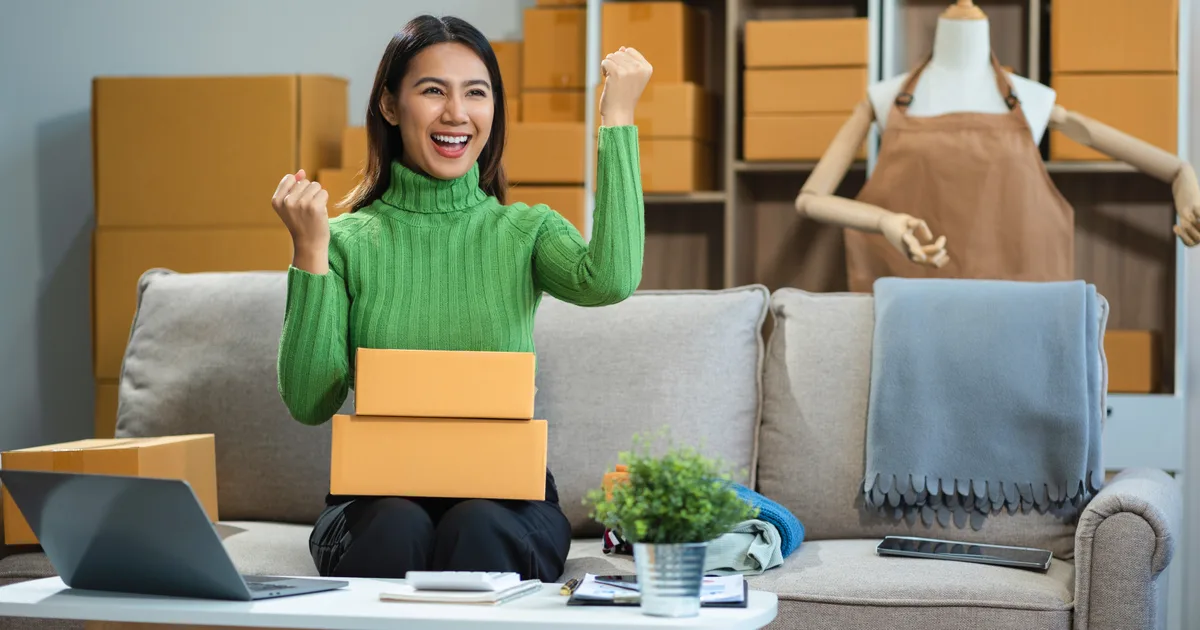 Une créatrice célèbre une vente entourée de ses colis